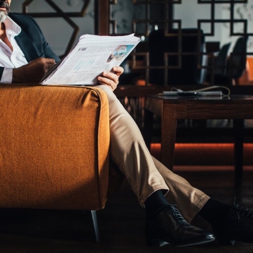 The essence of exceptional living a person sitting down in a chair reading something